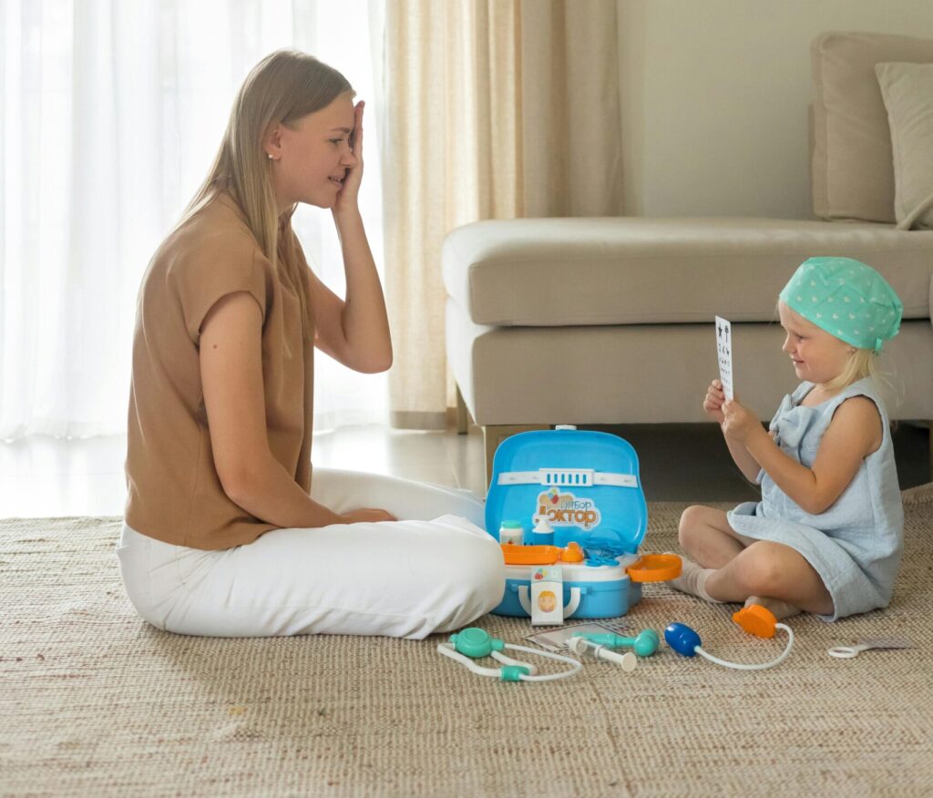 A mother and child playing with a doctor toy kit indoors, fostering imagination and bonding.