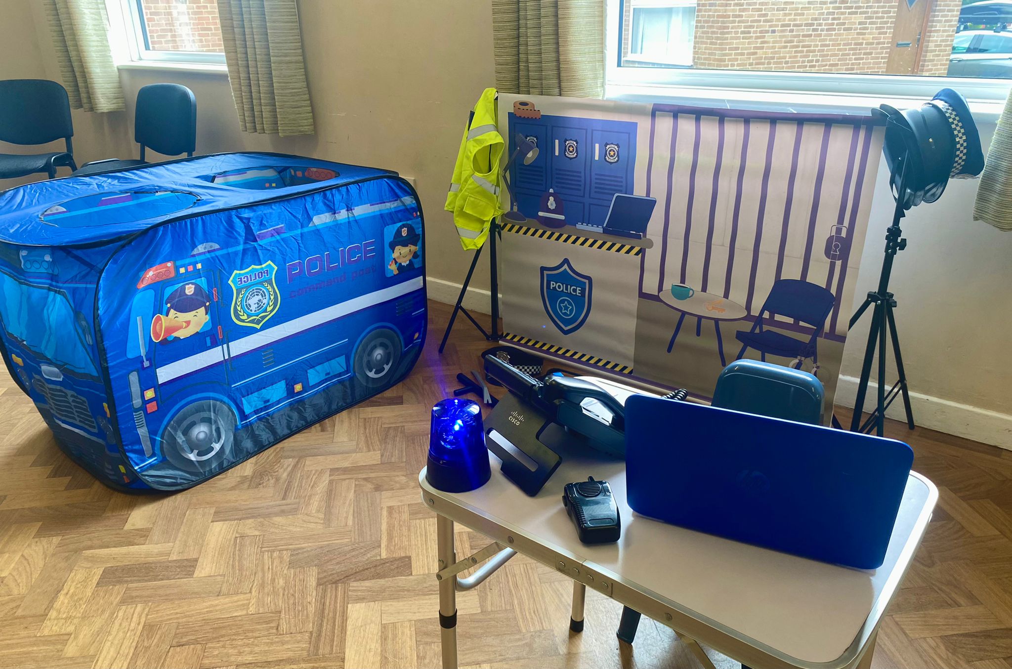 Police station role play area at a children's party in Walsall, with a police van play tent, flashing blue light, radio, police hat and hi-vis vest
